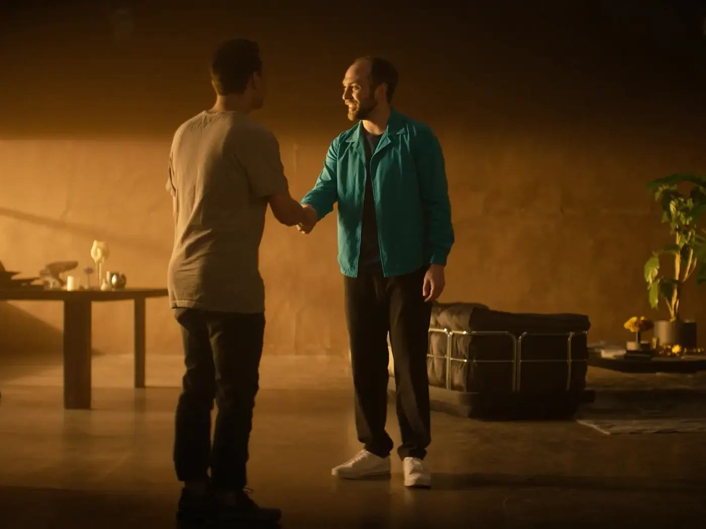 Two partners shaking hands in a warmly lit studio