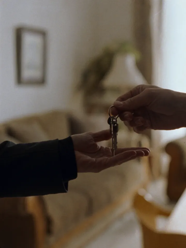 Keys handed over in a sunlit apartment